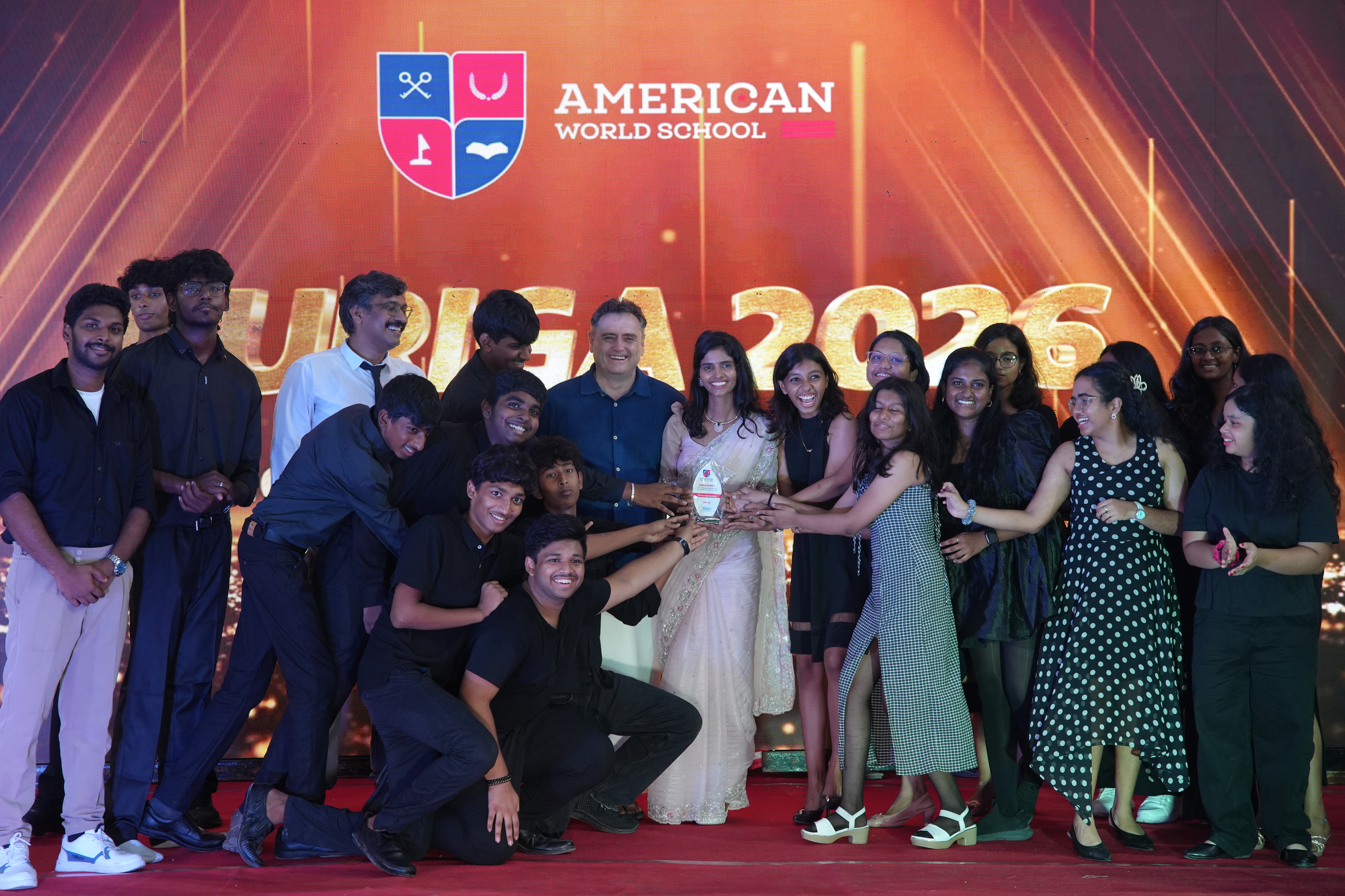 AWS students celebrating with a trophy on stage